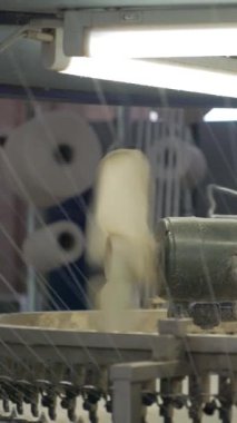 Dikey, arabalara kumaş dokuma. Fabrikadaki ipliklerden kumaş üretimi. Tekstil fabrikası endüstrisi. Kumaş yapma makineleri.