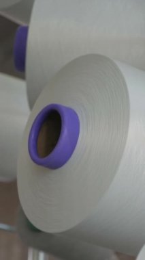 Dikey, arabalara kumaş dokuma. Fabrikadaki ipliklerden kumaş üretimi. Tekstil fabrikası endüstrisi. Kumaş yapma makineleri.