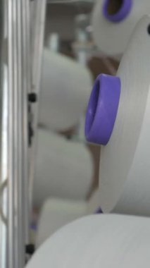 Dikey, arabalara kumaş dokuma. Fabrikadaki ipliklerden kumaş üretimi. Tekstil fabrikası endüstrisi. Kumaş yapma makineleri.