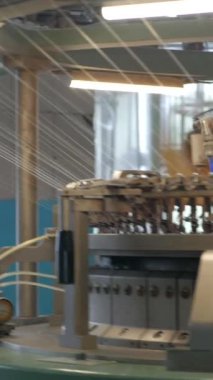 Dikey, arabalara kumaş dokuma. Fabrikadaki ipliklerden kumaş üretimi. Tekstil fabrikası endüstrisi. Kumaş yapma makineleri.