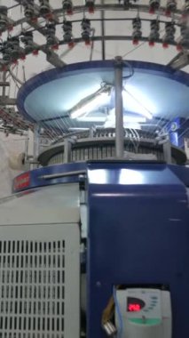 Dikey, arabalara kumaş dokuma. Fabrikadaki ipliklerden kumaş üretimi. Tekstil fabrikası endüstrisi. Kumaş yapma makineleri.
