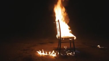 Dikey, sandalye yanıyor. Geceleri büyük mistik bir yangın. Büyük bir şenlik ateşi gece karanlığında yanar. Yangın, mobilyalar yanıyor..