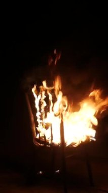Dikey, sandalye yanıyor. Geceleri büyük mistik bir yangın. Büyük bir şenlik ateşi gece karanlığında yanar. Yangın, mobilyalar yanıyor..