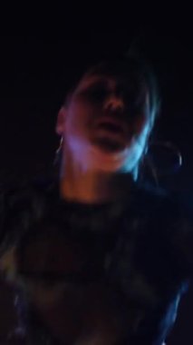 Vertical, Sexy woman dancing a seductive dance. A dancer girl with a big ass in a thong dances erotically in a dark hall. Twerk, high heels, striptease