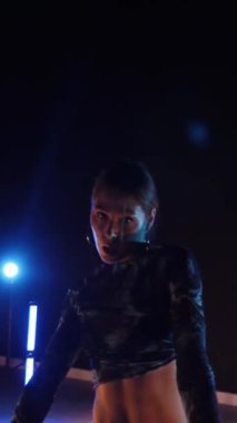 Vertical, Sexy woman dancing a seductive dance. A dancer girl with a big ass in a thong dances erotically in a dark hall. Twerk, high heels, striptease