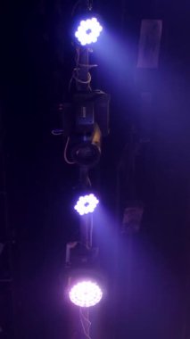 Dikey. Sahne ışıklarının oluşturduğu bir takımyıldızı, karanlık uzayda canlı ışınlar yayıyor. Sahne ışıklarının karmaşık ağı, performans alanının görünmeyen derinliklerini aydınlatıyor..