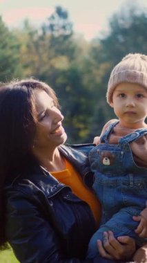 Dikey, sıcak öğleden sonra güneşi bir anne ve çocuğu yıkıyor, ortak bakışlarından belli oluyor. Parkta bir çocuğun mucizesinin bir annenin sevgisiyle buluştuğu hassas bir an. Güneş ışığı içinden akar.