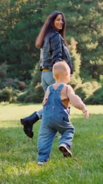 Aile pikniği, altın güneş ışığı banyosu, parkta elmaları ve kahkahaları paylaşmak. Sıcak bir sonbahar öğleden sonrasında, bir aile çimlerin üzerinde basit bir pikniğin tadını çıkarıyor. Tatlı gülümsemeler ve paylaşılan elmalar, bir ailenin neşesi.