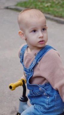 Küçük kaşif, dengeli bisikletleriyle güneşli çayırlarda geziniyor. Canlı bir park ortamında denge sanatında ustalaşan küçük bir binici. Altın saat, bir çocuğun yolculuğunu aydınlatıyor.