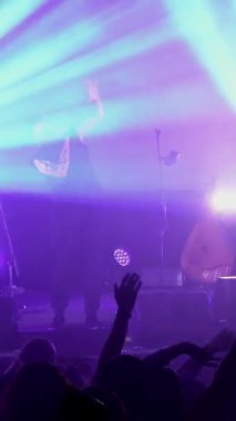Dikey olarak, bir rock grubu sahnede çalıyor. Dinleyiciler ellerini kaldırdı ve bir müzik grubunun rock konserine atladı. Grubun solisti, vokalisti izleyicilerle birlikte şarkı söylüyor. Davulcu, gitarist., 