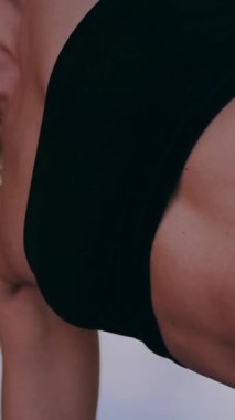 Dikey. Dinamik egzersiz pozu veren bir kadın. Stüdyo çalışması, hareket halindeki bir kadın vücudu. Fitness rutini. Zorlu bir egzersizde bir kadın vücudu. Bir kadın fiziksel egzersiz yapıyor. esneme, spor modeli