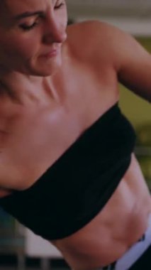 Dikey. Dinamik egzersiz pozu veren bir kadın. Stüdyo çalışması, hareket halindeki bir kadın vücudu. Fitness rutini. Zorlu bir egzersizde bir kadın vücudu. Bir kadın fiziksel egzersiz yapıyor. esneme, spor modeli