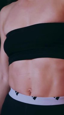 Dikey. Sporcu spor salonunda egzersizler yapar. Bir kadın kaslarını ve vücudunu eğitir. Seksi genç kadın spor salonunda simülatörlerle meşgul. Güzel spor vücudu..