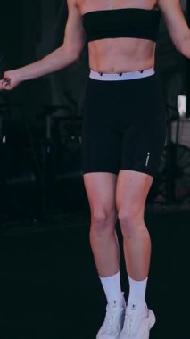 Dikey. Sporcu spor salonunda egzersizler yapar. Bir kadın kaslarını ve vücudunu eğitir. Seksi genç kadın spor salonunda simülatörlerle meşgul. Güzel spor vücudu..