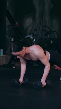 Dikey. Sporcu spor salonunda egzersizler yapar. Bir kadın kaslarını ve vücudunu eğitir. Seksi genç kadın spor salonunda simülatörlerle meşgul. Güzel spor vücudu..