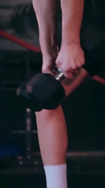 Dikey. Sporcu spor salonunda egzersizler yapar. Bir kadın kaslarını ve vücudunu eğitir. Seksi genç kadın spor salonunda simülatörlerle meşgul. Güzel spor vücudu..