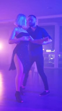 Dikey. Bir erkek ve bir kadın kizomba dansı yapıyor, salsa. Tutkulu bir tango canlı, mor ışıklar altında sergilenir. Heyecan verici enerjiyle birkaç dans. Büyüleyici bir zarafet ve ritim gösterisi. Dansçıların bağlantısı inkar edilemez..