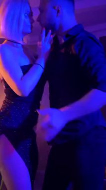 Dikey. Bir erkek ve bir kadın kizomba dansı yapıyor, salsa. Tutkulu bir tango canlı, mor ışıklar altında sergilenir. Heyecan verici enerjiyle birkaç dans. Büyüleyici bir zarafet ve ritim gösterisi. Dansçıların bağlantısı inkar edilemez..