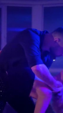 Dikey. Bir erkek ve bir kadın kizomba dansı yapıyor, salsa. Tutkulu bir tango canlı, mor ışıklar altında sergilenir. Heyecan verici enerjiyle birkaç dans. Büyüleyici bir zarafet ve ritim gösterisi. Dansçıların bağlantısı inkar edilemez..