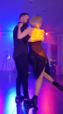 Dikey. Bir erkek ve bir kadın kizomba dansı yapıyor, salsa. Tutkulu bir tango canlı, mor ışıklar altında sergilenir. Heyecan verici enerjiyle birkaç dans. Büyüleyici bir zarafet ve ritim gösterisi. Dansçıların bağlantısı inkar edilemez..