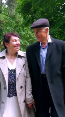 Dikey olarak, yaşlı bir çift yemyeşil alana karşı el ele yürür. Bir park sahnesi, son yıllarında bir çiftin sergilenmesi. Birbirine aşık bir büyükbaba ve büyükanne parkta yürürler.. 