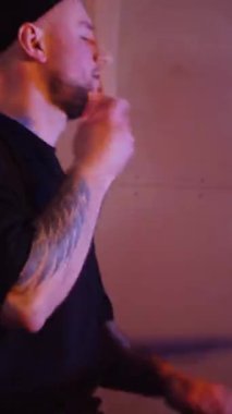 Dikey. Stüdyoda bir adam davul çalıyor. Sürücü müzisyen davulcu soğukkanlılıkla davulda rock çalar. Stüdyo, renk arkaplanı.