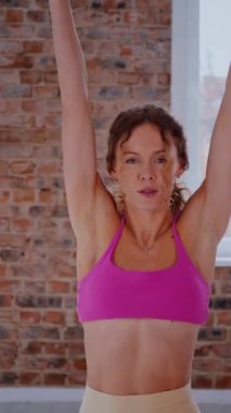 Dikey. Dinamik egzersiz pozu veren bir kadın. Stüdyo çalışması, hareket halindeki bir kadın vücudu. Fitness rutini. Zorlu bir egzersizde bir kadın vücudu. Bir kadın fiziksel egzersiz yapıyor. Esneme, Spor