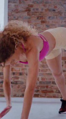 Dikey. Dinamik egzersiz pozu veren bir kadın. Stüdyo çalışması, hareket halindeki bir kadın vücudu. Fitness rutini. Zorlu bir egzersizde bir kadın vücudu. Bir kadın fiziksel egzersiz yapıyor. Esneme, Spor