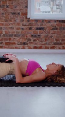 Dikey. Dinamik egzersiz pozu veren bir kadın. Stüdyo çalışması, hareket halindeki bir kadın vücudu. Fitness rutini. Zorlu bir egzersizde bir kadın vücudu. Bir kadın fiziksel egzersiz yapıyor. Esneme, Spor