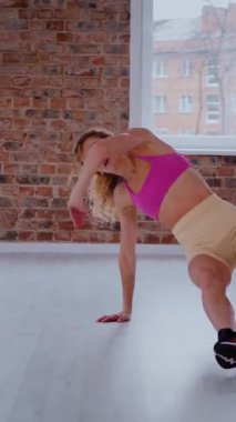 Dikey. Dinamik egzersiz pozu veren bir kadın. Stüdyo çalışması, hareket halindeki bir kadın vücudu. Fitness rutini. Zorlu bir egzersizde bir kadın vücudu. Bir kadın fiziksel egzersiz yapıyor. Esneme, Spor