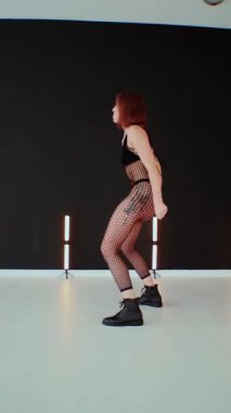 Dikey. Büyük kalçalı, tangalı bir dansçı kız koridorda erotik bir şekilde dans ediyor. Büyüleyici bir twerk, güçlü bir hareket ve ritim sergiliyor. Baştan çıkarıcı dans eden seksi kadın. Kıvranma, yüksek topuklar, striptiz..