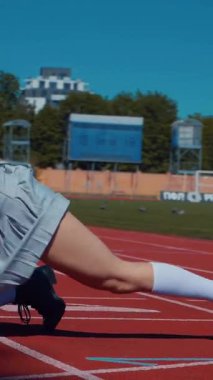 Dikey. Stadyum pistinde neşeyle dans eden iki ateşli kadın. Kısa etekli ponpon kızlar koşu pistinde mutlu bir şekilde dans ediyorlar. İki kız spor pistinde baştan çıkarıcı bir şekilde dans ediyor.