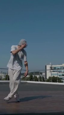 Dikey. Adam evin çatısında serin kanlılıkla break dans yapıyor. Bir adam enerjik bir atletik dans eder. Adam çatıda dans ederken hiç zorlanmadan break dans yapıyor. Şehir dansçısı çatıda hünerlerini gösteriyor. Breakdansçı yeteneklerini şehrin üzerinde sergiliyor..