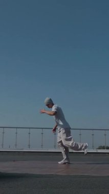 Dikey. Adam evin çatısında serin kanlılıkla break dans yapıyor. Bir adam enerjik bir atletik dans eder. Adam çatıda dans ederken hiç zorlanmadan break dans yapıyor. Şehir dansçısı çatıda hünerlerini gösteriyor. Breakdansçı yeteneklerini şehrin üzerinde sergiliyor..