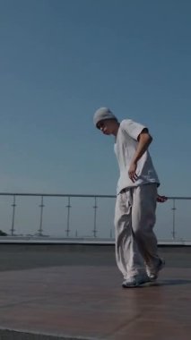 Dikey. Adam evin çatısında serin kanlılıkla break dans yapıyor. Bir adam enerjik bir atletik dans eder. Adam çatıda dans ederken hiç zorlanmadan break dans yapıyor. Şehir dansçısı çatıda hünerlerini gösteriyor. Breakdansçı yeteneklerini şehrin üzerinde sergiliyor..