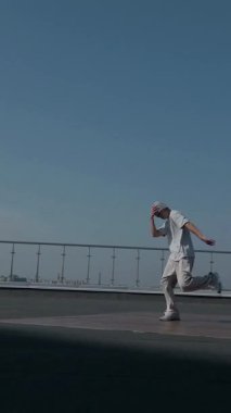 Dikey. Adam evin çatısında serin kanlılıkla break dans yapıyor. Bir adam enerjik bir atletik dans eder. Adam çatıda dans ederken hiç zorlanmadan break dans yapıyor. Şehir dansçısı çatıda hünerlerini gösteriyor. Breakdansçı yeteneklerini şehrin üzerinde sergiliyor..