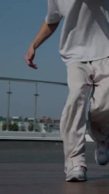 Dikey. Adam evin çatısında serin kanlılıkla break dans yapıyor. Bir adam enerjik bir atletik dans eder. Adam çatıda dans ederken hiç zorlanmadan break dans yapıyor. Şehir dansçısı çatıda hünerlerini gösteriyor. Breakdansçı yeteneklerini şehrin üzerinde sergiliyor..