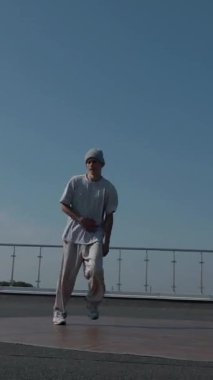 Dikey. Adam evin çatısında serin kanlılıkla break dans yapıyor. Bir adam enerjik bir atletik dans eder. Adam çatıda dans ederken hiç zorlanmadan break dans yapıyor. Şehir dansçısı çatıda hünerlerini gösteriyor. Breakdansçı yeteneklerini şehrin üzerinde sergiliyor..