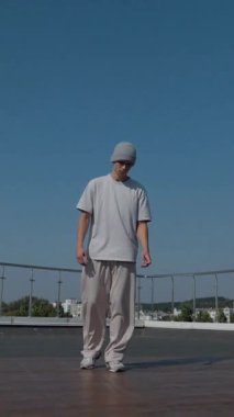 Dikey. Adam evin çatısında serin kanlılıkla break dans yapıyor. Bir adam enerjik bir atletik dans eder. Adam çatıda dans ederken hiç zorlanmadan break dans yapıyor. Şehir dansçısı çatıda hünerlerini gösteriyor. Breakdansçı yeteneklerini şehrin üzerinde sergiliyor..