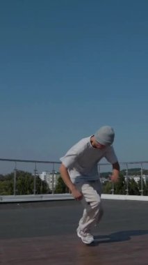 Dikey. Adam evin çatısında serin kanlılıkla break dans yapıyor. Bir adam enerjik bir atletik dans eder. Adam çatıda dans ederken hiç zorlanmadan break dans yapıyor. Şehir dansçısı çatıda hünerlerini gösteriyor. Breakdansçı yeteneklerini şehrin üzerinde sergiliyor..