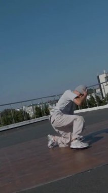 Dikey. Adam evin çatısında serin kanlılıkla break dans yapıyor. Bir adam enerjik bir atletik dans eder. Adam çatıda dans ederken hiç zorlanmadan break dans yapıyor. Şehir dansçısı çatıda hünerlerini gösteriyor. Breakdansçı yeteneklerini şehrin üzerinde sergiliyor..