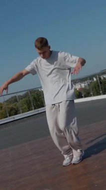 Dikey. Adam evin çatısında serin kanlılıkla break dans yapıyor. Bir adam enerjik bir atletik dans eder. Adam çatıda dans ederken hiç zorlanmadan break dans yapıyor. Şehir dansçısı çatıda hünerlerini gösteriyor. Breakdansçı yeteneklerini şehrin üzerinde sergiliyor..