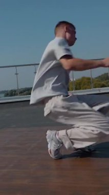 Dikey. Adam evin çatısında serin kanlılıkla break dans yapıyor. Bir adam enerjik bir atletik dans eder. Adam çatıda dans ederken hiç zorlanmadan break dans yapıyor. Şehir dansçısı çatıda hünerlerini gösteriyor. Breakdansçı yeteneklerini şehrin üzerinde sergiliyor..