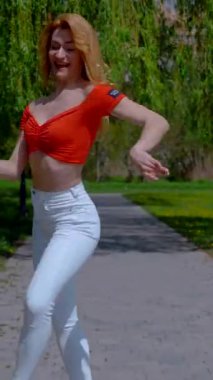 Dikey. Güzel enerjik kadın dışarıda salsa yapıyor. Bachata yapan genç bir kadın, açık gökyüzünün altında parkta kizomba yapıyor. Şehrin kaldırımında ateşli bir kadının baştan çıkarıcı dansı..
