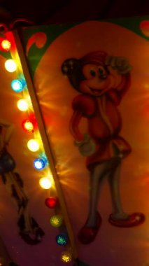 Dikey. Gece gökyüzüne karşı parlayan ışıklarla süslenmiş canlı bir eğlence gezisi. Luna Parkı. Parlak yeşil ışıklar lunaparktaki dönen bir atlıkarıncanın üzerinde dans ediyor. Ekstrem atlıkarınca neşeyle dönüyor, büyüleyici yeşil ışıklarla aydınlatılıyor