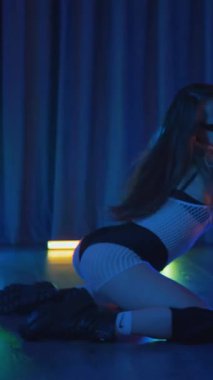 Anime tarzında siyah gözlüklü genç bir kadın erotik bir şekilde dans ediyor. Siyah şortlu yarı traşlı kız karanlık uzayda zarafetle hareket ediyor. Sahnedeki disko kulübünde striptiz..