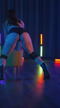 Anime tarzında siyah gözlüklü genç bir kadın erotik bir şekilde dans ediyor. Siyah şortlu yarı traşlı kız karanlık uzayda zarafetle hareket ediyor. Sahnedeki disko kulübünde striptiz..