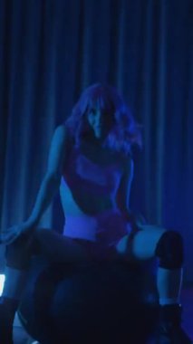 Dikey. Genç bir kadın loş ışıklı neon odada merdivende erotik dans eden bir budala. Yarı tıraşlı bir kız merdivende dikiliyor. Koyu uzayda baştan çıkarıcı bir zarafetle yürüyor. Kulüpte striptiz..