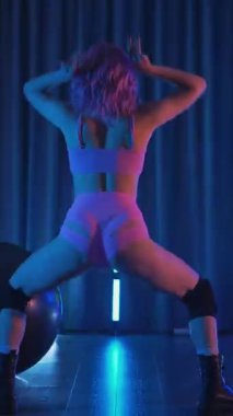 Dikey. Genç bir kadın loş ışıklı neon odada merdivende erotik dans eden bir budala. Yarı tıraşlı bir kız merdivende dikiliyor. Koyu uzayda baştan çıkarıcı bir zarafetle yürüyor. Kulüpte striptiz..