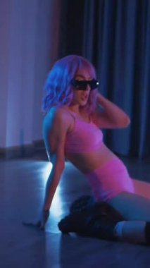 Dikey. Genç bir kadın loş ışıklı neon odada merdivende erotik dans eden bir budala. Yarı tıraşlı bir kız merdivende dikiliyor. Koyu uzayda baştan çıkarıcı bir zarafetle yürüyor. Kulüpte striptiz..